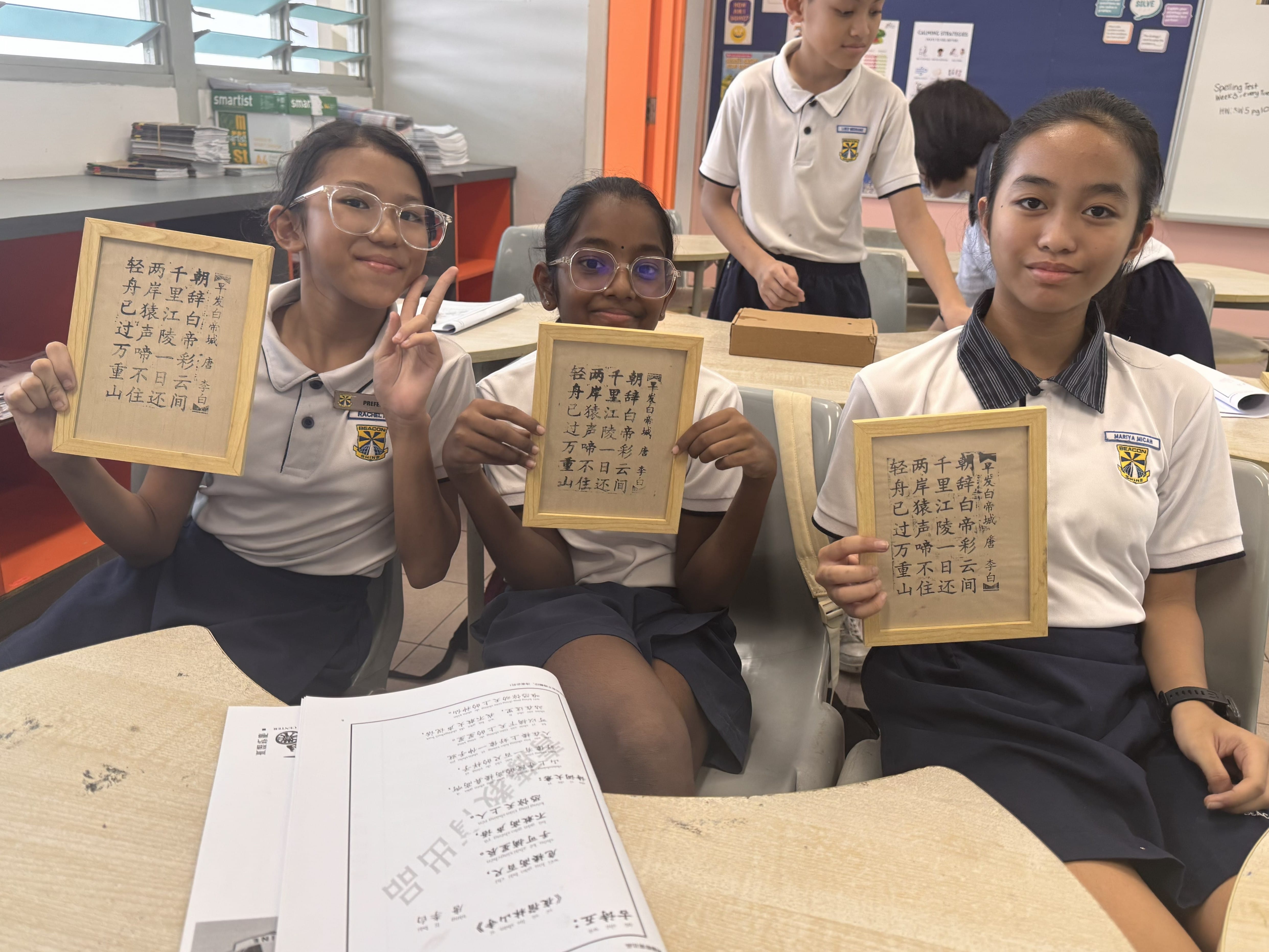 P5 CL Students proudly displaying their completed framed Chinese poem prints.